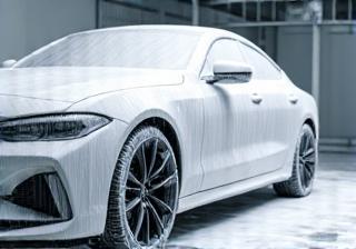 Car undergoing a thorough decontamination wash with foam